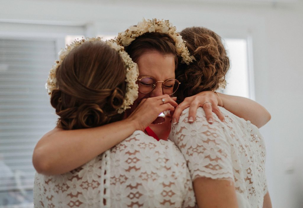Moment émotif lors de préparation de la mariée, entourée de ses témoins avant la cérémonie.