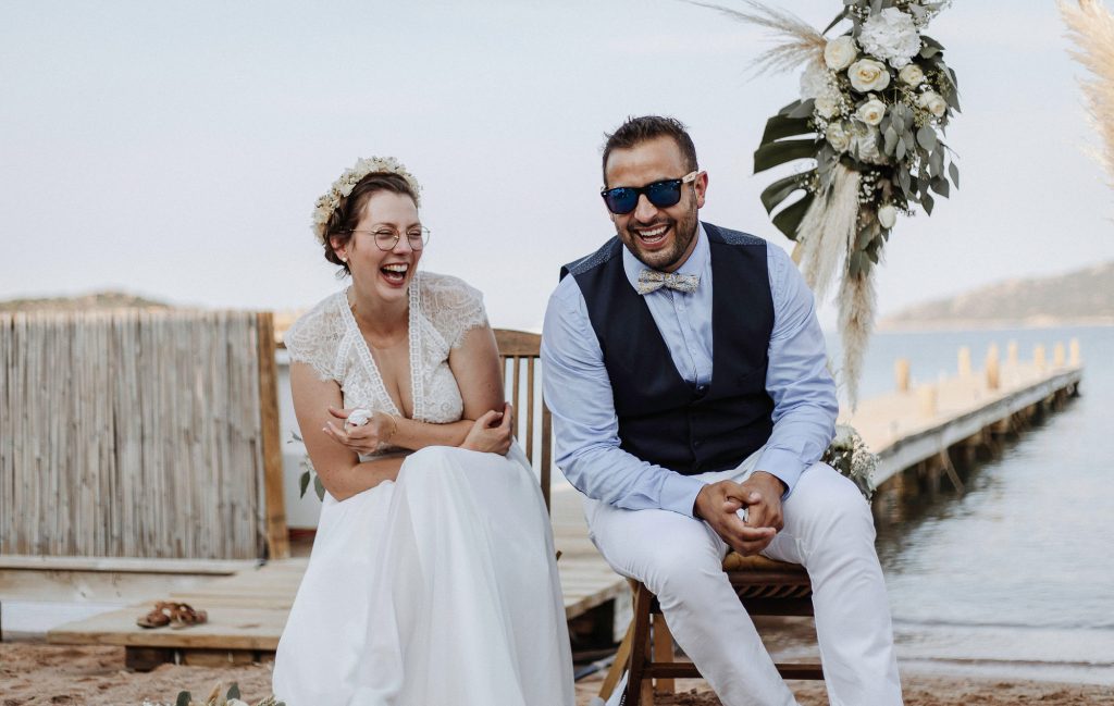 moment de rire des mariés dans un mariage lors d'une cérémonie laïque en extérieur en Bretagne